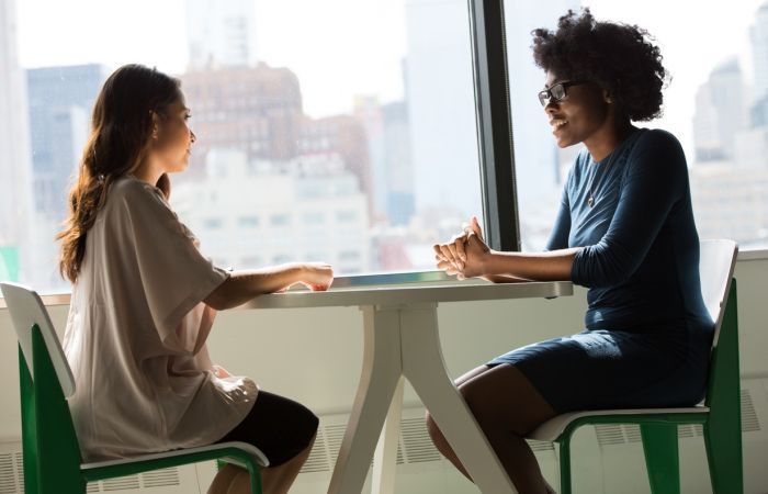 Two people seated face to face at a table